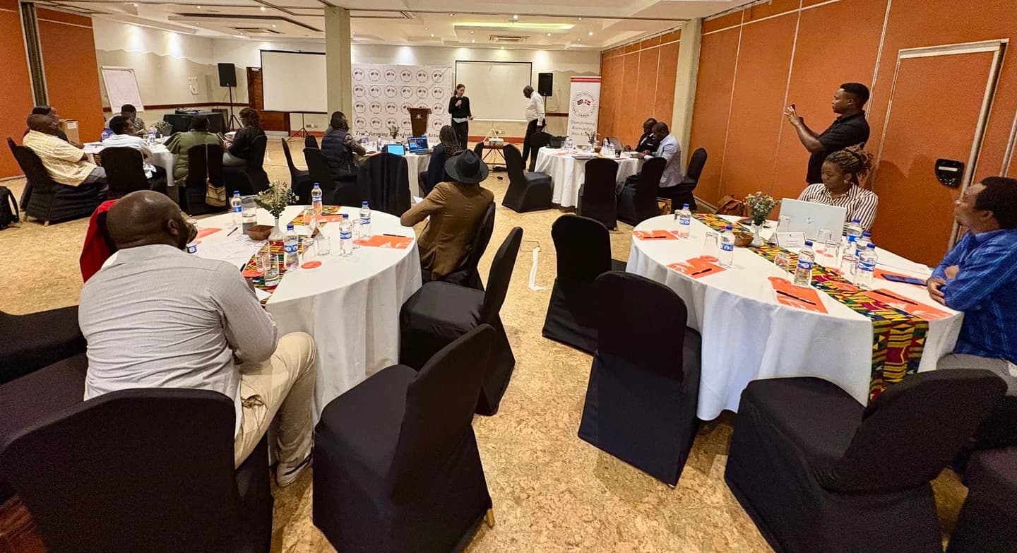 Participants seated around tables during a workshop presentation